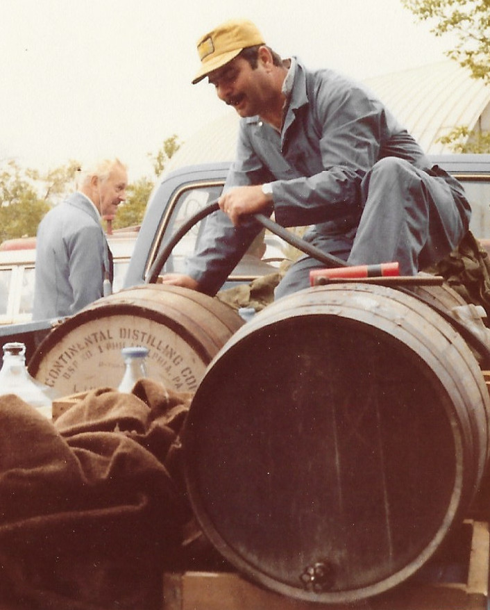 Long time employee, Bernie Bruder pumping grape juice into a barrel