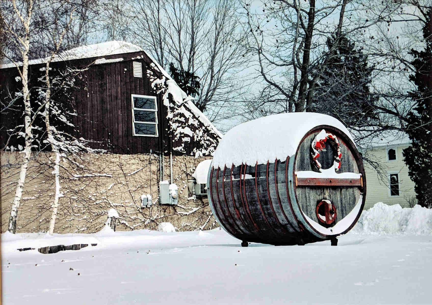 Wine cask in front of the winery, in snow with Christmas decorations