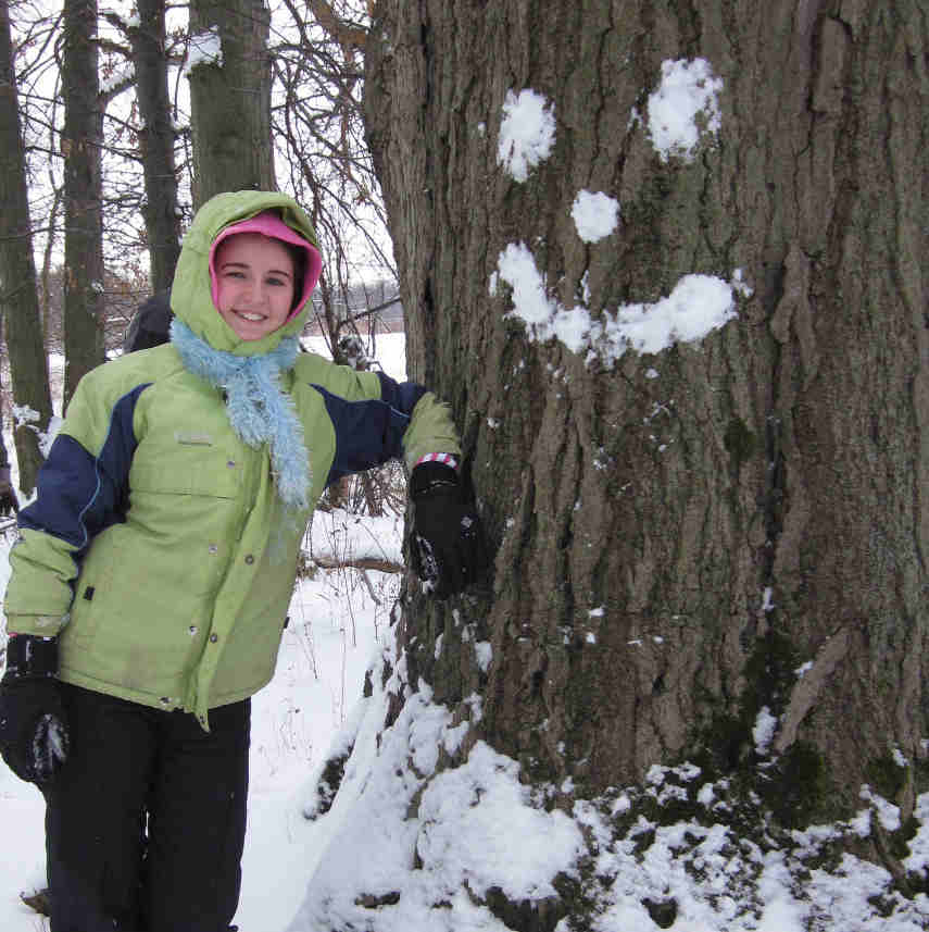 Josephine Klingshirn next to a smiley face made of snow