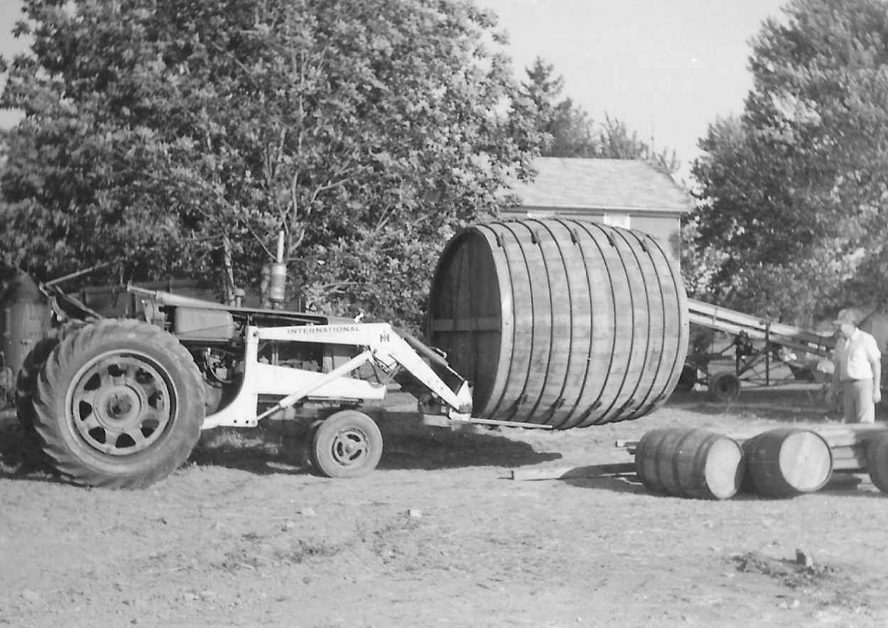 Tractor moving a large wine cask into the winery