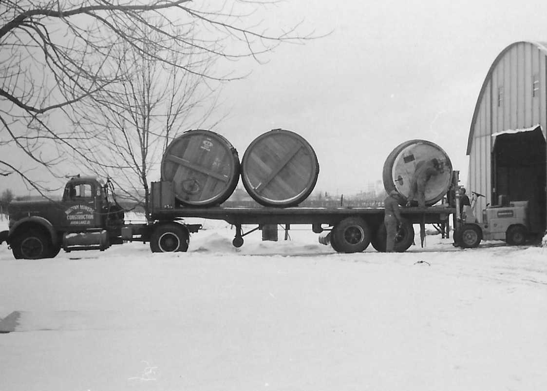 Large wine casks being unloaded from a Novotny tractor trailer truck.
